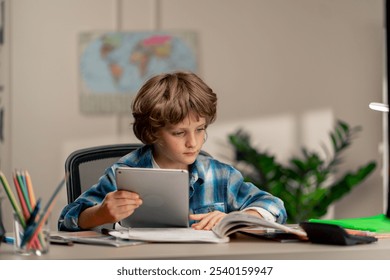 in the children's room a schoolboy in a white sweater and a blue checkered shirt at a desk does homework reads assignments on tablet modern education - Powered by Shutterstock