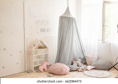 children's room in white color with grey canopy and pink pillows on the floor