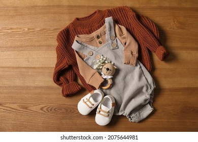 Children's Shoes, Clothes And Toy On Wooden Table, Flat Lay