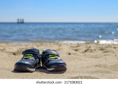 Children's Shoes On A Sandy Beach