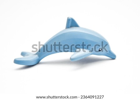 Children's small bathtub rubber dolphin isolated on white background. A small child's toy in the shape of a dolphin. Front view of a squirting rubber dolphin bath toy. Squeaky rubber dolphin toy.