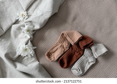 Children's socks are laid out on a linen bedspread. Photo content for a baby store. 