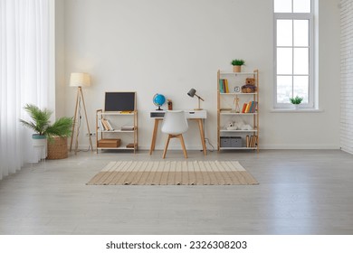 Children's study room at home. Modern spacious interior with desk, chair, bookshelves, chalkboard, lamps, Earth globe, plants, boxes, toys, rug, and laminate flooring. Unisex design for boy or girl - Powered by Shutterstock