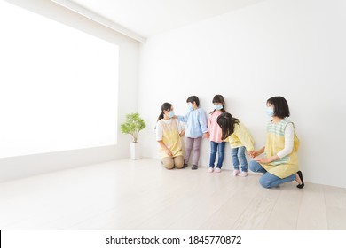 Children's Teacher Playing In Kindergarten With A Mask On