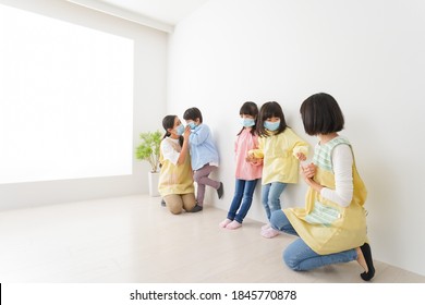 Children's Teacher Playing In Kindergarten With A Mask On