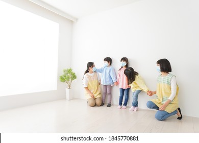 Children's Teacher Playing In Kindergarten With A Mask On