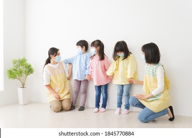 Children's Teacher Playing In Kindergarten With A Mask On