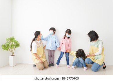 Children's Teacher Playing In Kindergarten With A Mask On