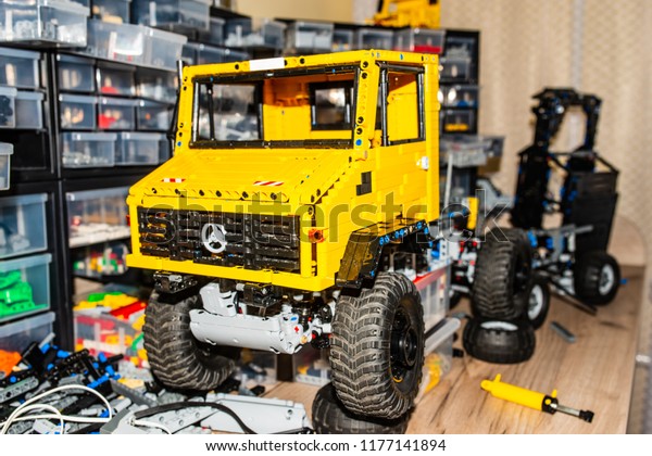 Children\'s toy car, assembled from the details\
of the designer. Plastic parts for children\'s designer in the\
orange organizer.