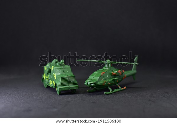 Children\'s toy in the form of\
military trucks and helicopters on a black isolated\
background.