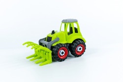Children's Toy Green Tractor On A White Isolated Background.Plastic Child Toy On White Backdrop. Construction Vehicle. Children's Toy. Tractor Toy.