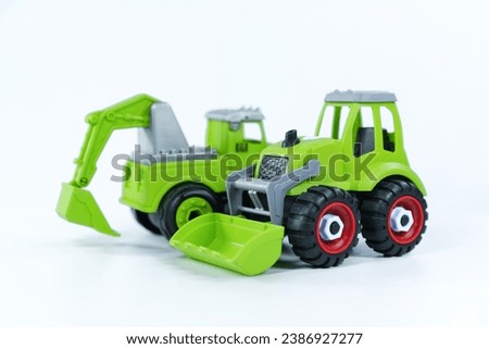 
Children's toy green tractor on a white isolated background.Plastic child toy on white backdrop. Construction vehicle. Children's toy. Tractor Toy.