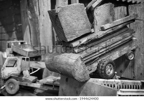 Children\'s toy made of wood in the shape of a\
car, made of wood. Rural farm, soft\
focus
