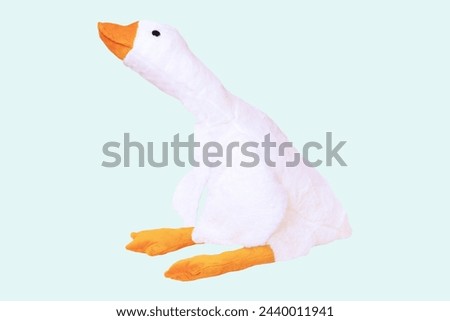 Childrens toy stuffed animals. Soft white plush toy duck for kids isolated on a light blue background. Duck teddy toy. White duck for playing.