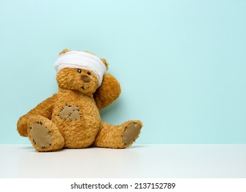 Children's Toy Teddy Bear Sits With A Bandaged Head. Childhood Trauma Concept