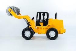 Children's Toy Yellow Tractor On A White Isolated Background.Plastic Child Toy On White Backdrop. Construction Vehicle. Children's Toy. Tractor Toy.