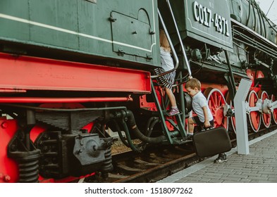 Children's Travel, Travel With A Child. A Boy With A Suitcase In His Hands Climbs The Steep Stairs Of The Train, Getting Into The Carriage. The Child Goes To Sea, On Vacation