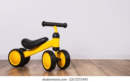 Children's tricycle for the little ones in the children's room. Children's leisure time. Copy space.