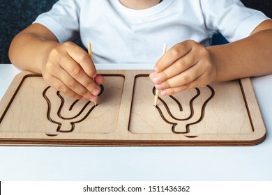 Children's Wooden Toy. Board For Interhemispheric Development Of The Brain. Children's Hands Close-up. Child Development Retardation. Wooden Labyrinth For Speech Therapist. Montessori Games For Child 