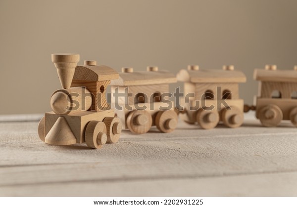Children\'s wooden toy, a steam engine, on a\
wooden white\
background