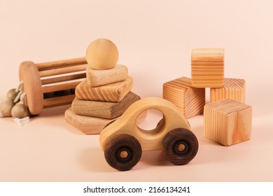 Children's wooden toys on a pink background. Cubes, pyramid, car. The concept of children's education and early development according to the Montessori method. Natural eco-friendly materials. - Shutterstock ID 2166134241