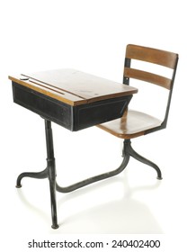 A child's antique, flip-top wood and metal school desk.  On a white background.
