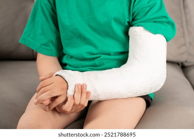 A child's arm is broken.Child with a fractured limb indoor. fracture injury in the summer holiday. Kid is moving fingers in plaster cast on the arm - Powered by Shutterstock