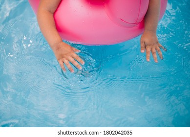 Child`s Arms In Swiming Pool From Above.