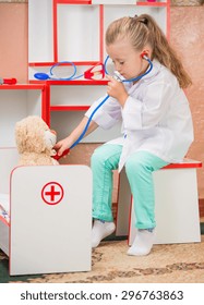 child's doctor examines a teddy bear