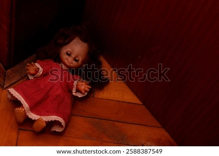a child's doll with curly hair, blue eyes and a red dress