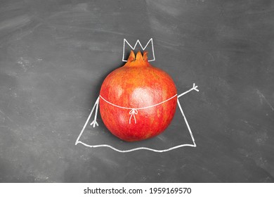 Child's Drawing Of A Red Ripe Pomegranate With A Crown And Royal Cloak On A Chalk Board