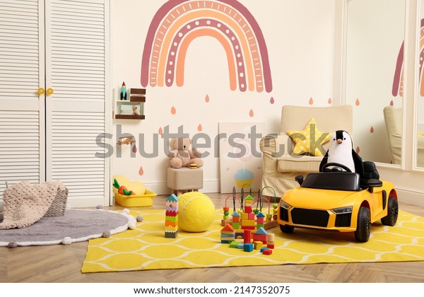 Child\'s electric\
car and other toys in\
playroom
