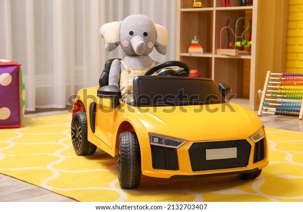 Child\'s\
electric car with toy elephant in\
playroom