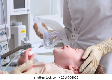 The Child's Exit From Anesthesia. Baby Is Crying. Anesthesia For A Child. Work Of A Physician Reaoimatologist And Anesthesiologist. Life Saving.Oxygen Mask.