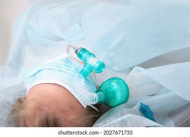 Child's Face Is Covered With A Mask. A Breathing Tube In The Mouth. The Child Is Under Anesthesia. Preparing For Surgery. Copy Space.