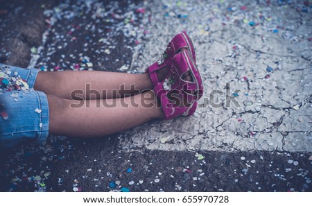 Child's feet on the road strewn with confetti