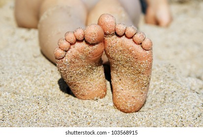 Child's Feet In The Sand Close-up