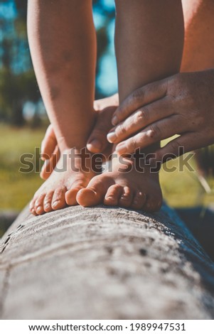 childs feet walking on balance log