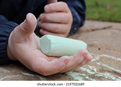 Child's Hand With Chalk Drawing Chalk Picture On Ground