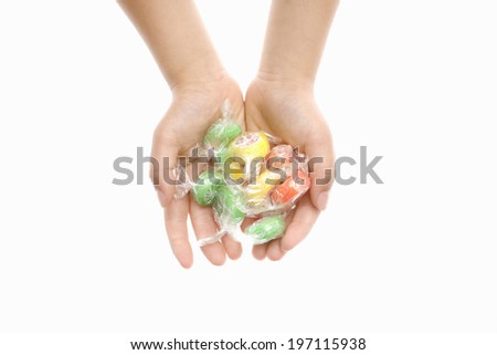 A Child'S Hand Holding A Candy