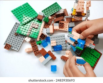 A child's hand is holding a Lego Minecraft toy