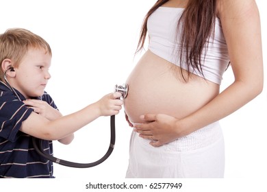 A Childs Hand Is Holding A Stethascope On The Belly Of A Pregnant Woman.