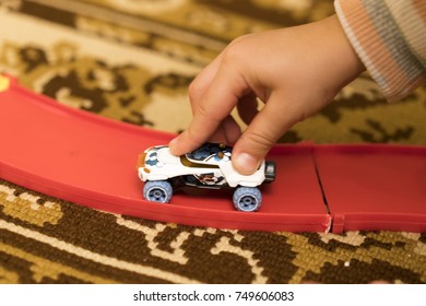 Child's hand holding a toy car.