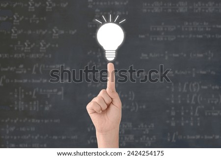 Child's hand and light bulb with difficult math questions background