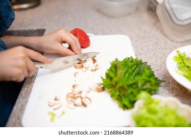 Child's Hand Making Salad At Home