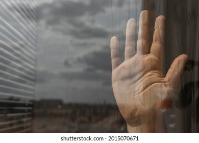 Child's hand on the window. Close-up hand on dark background