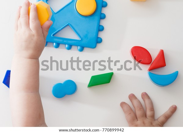Child\'s hand, playing with toys.,\
educational toys, arranging and sorting colors and\
sizes.