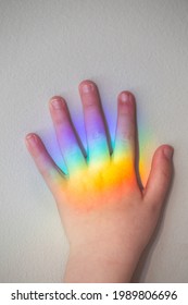 Child's Hand With Rainbow From A Prism Reflected On It