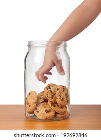Child's hand reaching out to take cookies from a jar 
