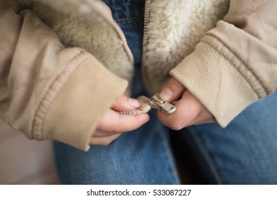 Child's Hand Trying To Close The Zipper